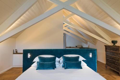 a bedroom with a large bed with blue pillows at Dimora Cottanera in Castiglione di Sicilia