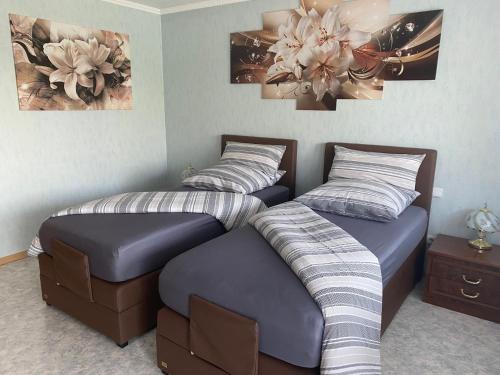 two beds in a room with paintings on the wall at Berta in Neunkirchen