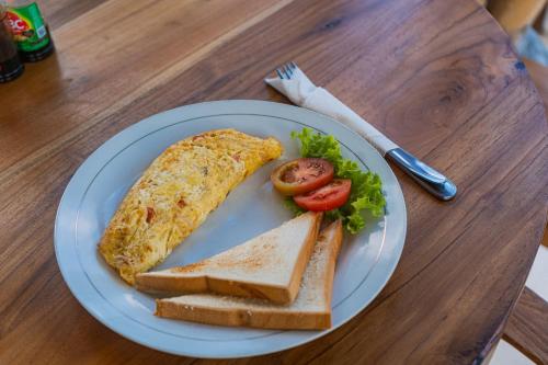 a plate of food with an omelet and toast at Tregge Surf Camp Uluwatu in Uluwatu