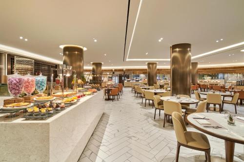 a restaurant with tables and chairs and a buffet at Landing Jeju Shinhwa World Hotel in Seogwipo