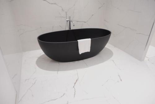 a black bath tub sitting on top of a white wall at Best Western Plus San Damianu in Sartène