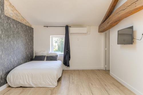 une chambre avec un lit blanc et une fenêtre dans l'établissement Le Düsseldorf - Les appartements de l'olivier, à Loyettes