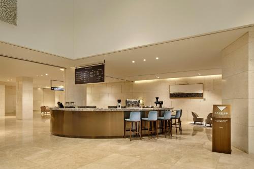 a lobby with a bar and stools in a building at Landing Jeju Shinhwa World Hotel in Seogwipo