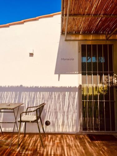 a chair and a table in front of a building at Casale Oliveta in Orbetello