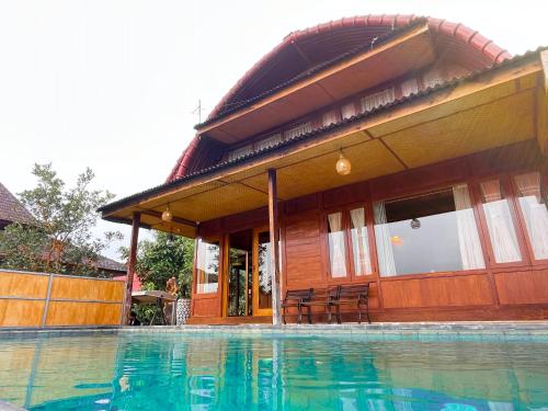 a house with a swimming pool in front of it at Villa Gajah Mas in Baturiti