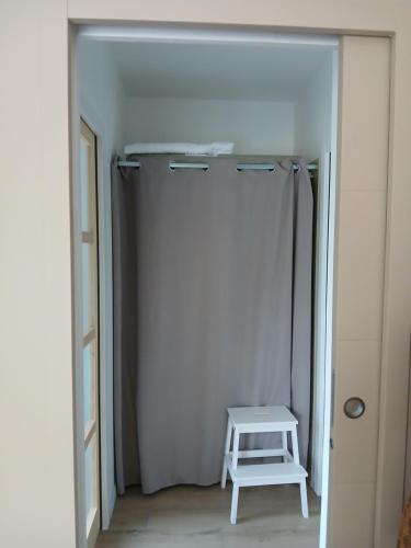 a white closet with a stool in a room at Chambre avec terrasse et salle de bain privative in Saint-Thurial