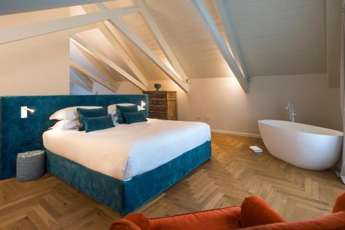 a bedroom with a large bed and a bath tub at Dimora Cottanera in Castiglione di Sicilia