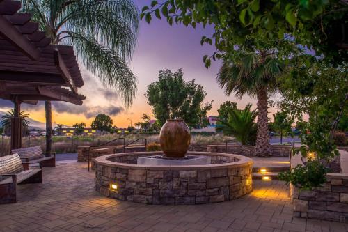 a fountain in a park with benches and a sunset at SpringHill Suites Temecula Valley Wine Country in Temecula