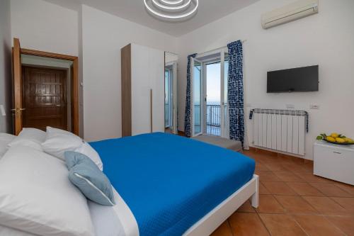 a bedroom with a blue bed and a television at Salvo's House in Furore