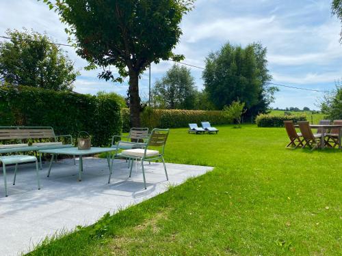 a picnic table and chairs in a grassy yard at Le Veenbahn in Deidenberg