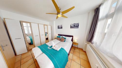 a bedroom with a bed with a ceiling fan at Zentral Altstadt Chur - Bahnhofsnah - Ferienwohnung - Bernina Express - Solution-Grischun in Chur