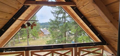 a large window in a wooden cabin with a view at Brvnara Marinković na Sekulićima in Sekulić 