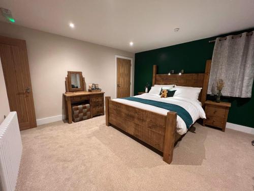 a bedroom with a large bed and a green wall at Bulls Head - Holymoorside in Chesterfield