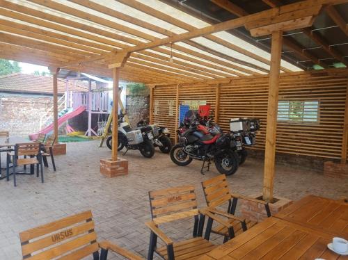 two motorcycles parked in a building with tables and chairs at Conacul Ancuței in Brad