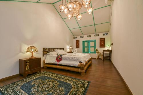 una camera da letto con un letto e un lampadario di Ohana House HQ a Malacca