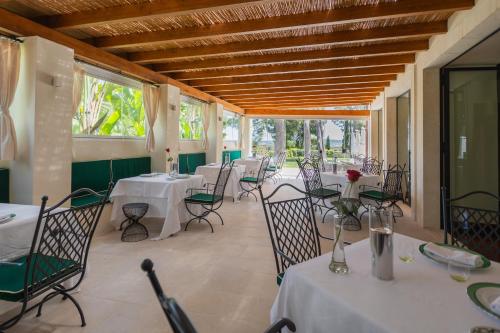 a room with tables and chairs with white table cloth at Il San Corrado di Noto in Noto