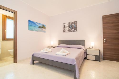 a white bedroom with a bed and a bathroom at LA PERLA DEL MARE Nuovissimo Affittacamere in Alghero