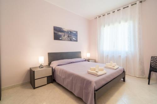 a bedroom with a bed with two towels on it at LA PERLA DEL MARE Nuovissimo Affittacamere in Alghero