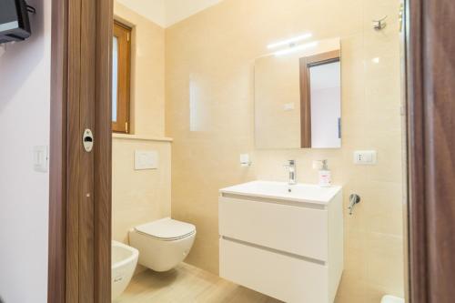 a bathroom with a sink and a toilet and a mirror at LA PERLA DEL MARE Nuovissimo Affittacamere in Alghero