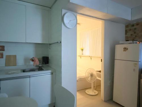 ソウルにあるHongdae Cozy42のキッチン(冷蔵庫付)、壁掛け時計