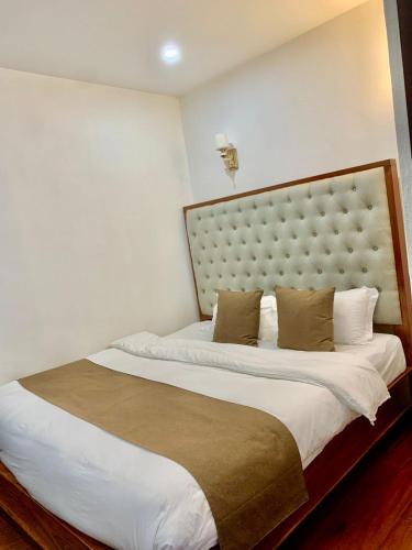 a bedroom with a large bed with a large headboard at Happy hour boutiquehotel in Luang Prabang
