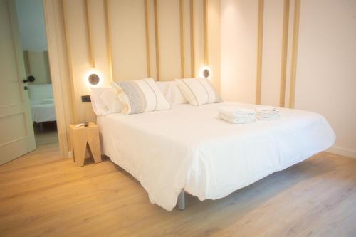 a white bed with white sheets and pillows on it at L'indret del Pedraforca Adults Only in Saldés