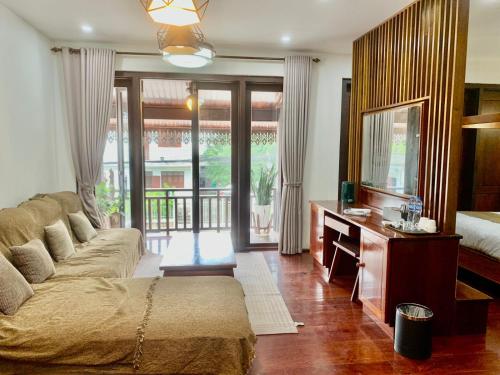 a living room with a couch and a mirror at Happy hour boutiquehotel in Luang Prabang