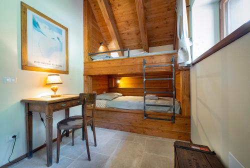 a bedroom with a bunk bed and a desk and a bed at Baita Eyra - Villaggio dei Crodini in Cravegna