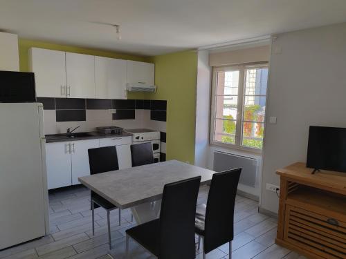 une cuisine avec une table et des chaises dans une cuisine dans l'établissement Apparts Gites Cholet centre, à Cholet