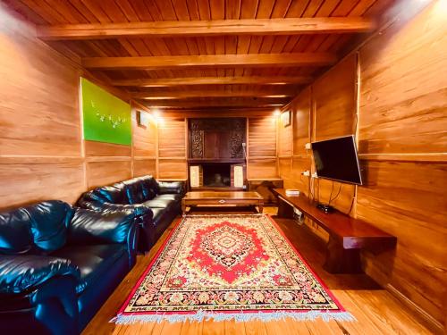 a living room with a leather couch and a television at Villa Gajah Mas in Baturiti