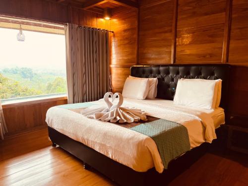 a bedroom with a bed with a large window at Villa Gajah Mas in Baturiti