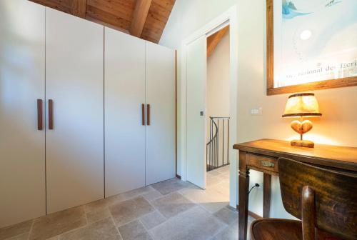 a room with white cabinets and a desk with a lamp at Baita Eyra - Villaggio dei Crodini in Cravegna
