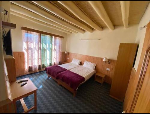 a bedroom with a large bed in a room at The Chandan Guest House Ladakh by LexStays in Leh