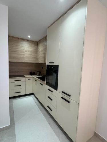 a kitchen with white cabinets and a black appliance at Apartmani Bare in Jajce