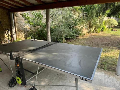 a ping pong table sitting under a porch at Charmant Duplex Le Vesinet in Le Vésinet