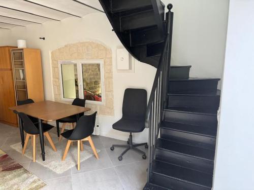 a dining room with a table and chairs and stairs at Charmant Duplex Le Vesinet in Le Vésinet