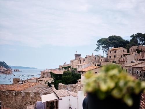 a view of a town with buildings and the ocean at Hostal Boutique Es Menut in Tossa de Mar