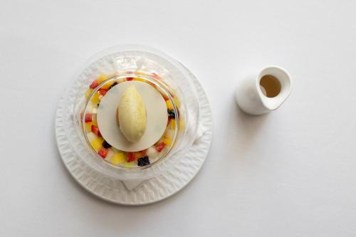 a cup of coffee and a plate with a cookie on it at Il San Corrado di Noto in Noto