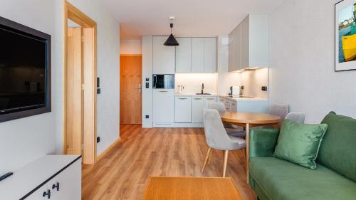 a living room with a green couch and a table at Apartamenty Helski Brzeg in Hel