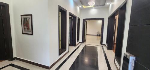 a hallway with black and white walls and black doors at Haven Lodge, Islamabad in Islamabad