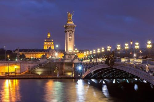 un pont sur une rivière avec une ville la nuit dans l'établissement Parisiandaydreamhouseboat, à Paris