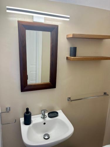 a bathroom with a sink and a mirror at Paros Home in Kampos Paros
