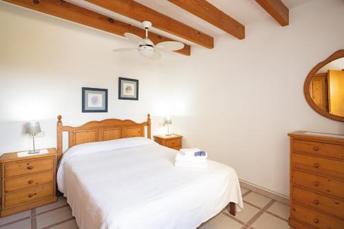 a bedroom with a bed and a ceiling fan at Finca con piscina Es Baladre in Capdepera