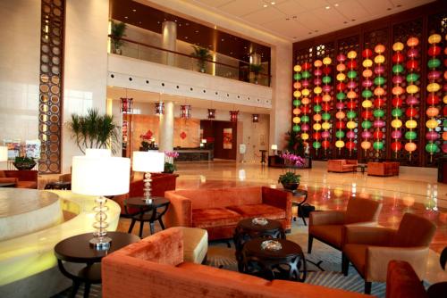 a lobby with couches and chairs and a colorful wall at HJ International Hotel in Dongguan