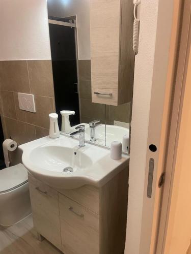 a bathroom with a sink and a toilet at Camelia's House in Olbia