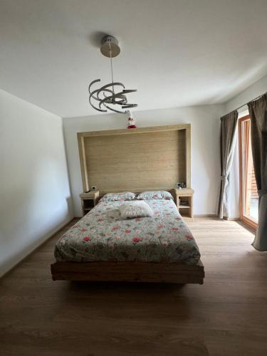 a bedroom with a bed and a large window at B&B antico tabià dolomitico in Santo Stefano di Cadore