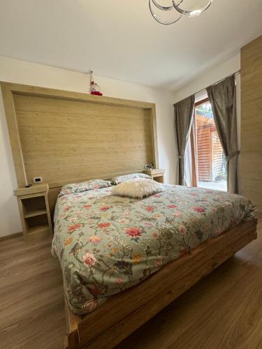 a bedroom with a large bed with a wooden headboard at B&B antico tabià dolomitico in Santo Stefano di Cadore