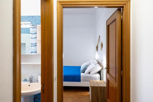 a bedroom with a bed and a bathroom with a sink at Rosy's Room in Furore