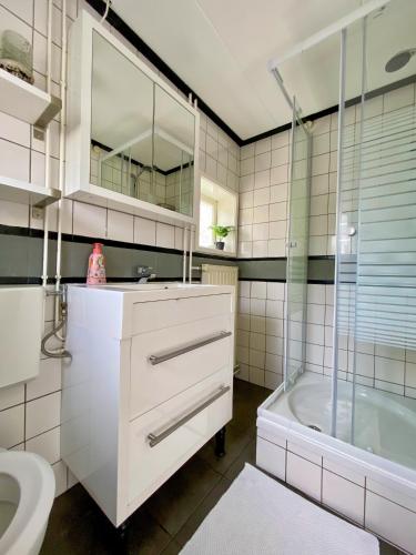 a bathroom with a sink and a shower and a tub at La Mare in Zoutelande