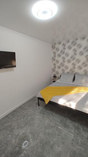 a bedroom with a large bed with a yellow blanket at Vegas luxury apartment in Constanţa